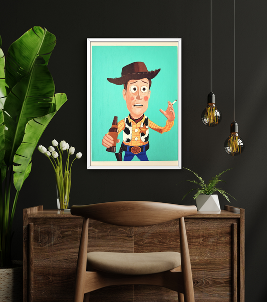 Framed artwork of a Woody from Toy Story with a cowboy hat on a wall in a room with a wooden desk and plants.