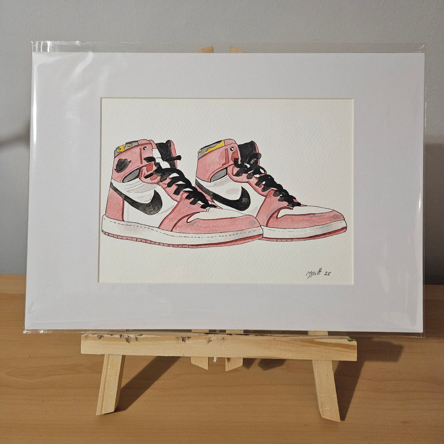 Original painting of Nike Air Jordan sneakers in watercolour, mounted and displayed on an easel.