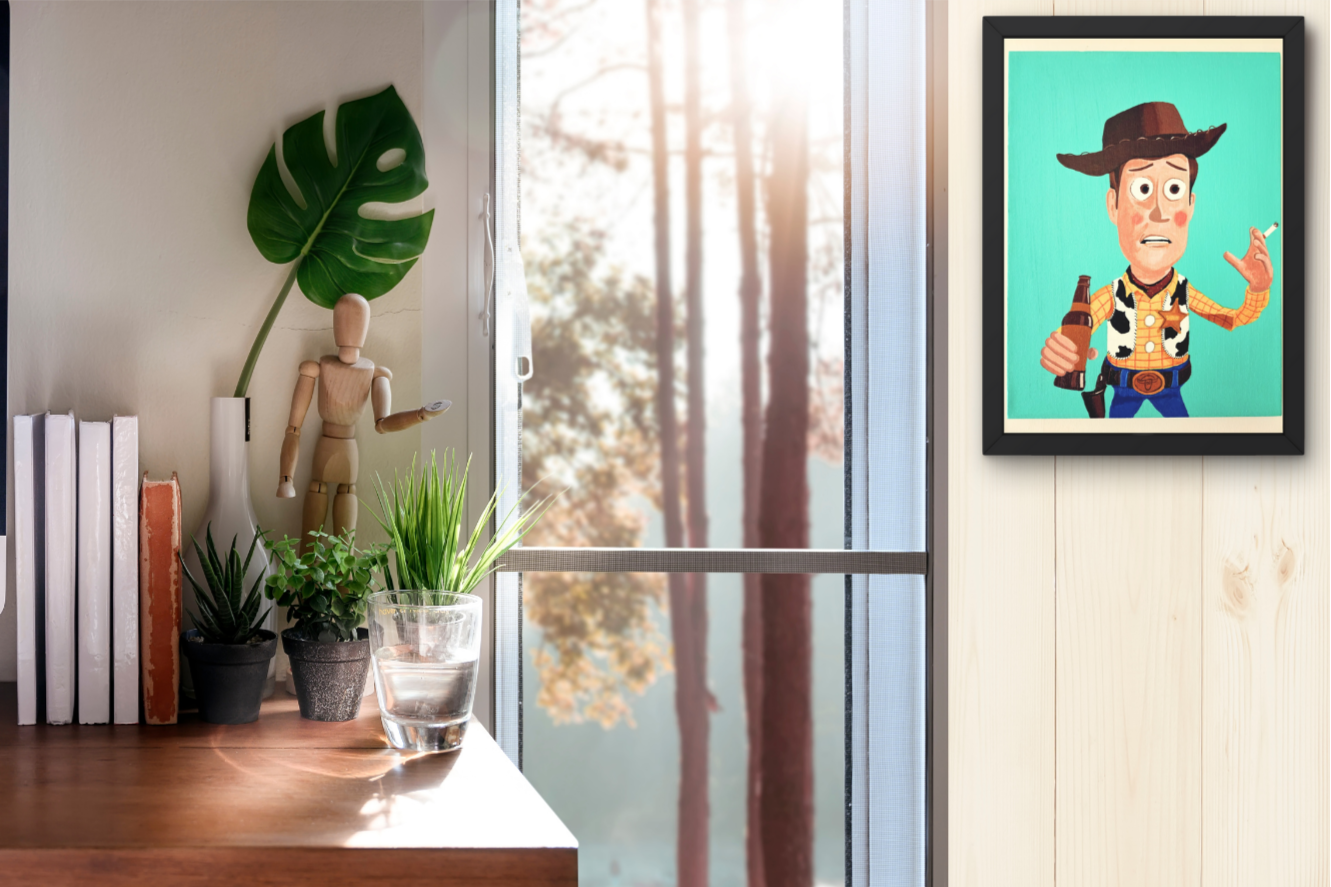 Framed artwork of a Woody Toy Story on a wall with a window and plants in the background